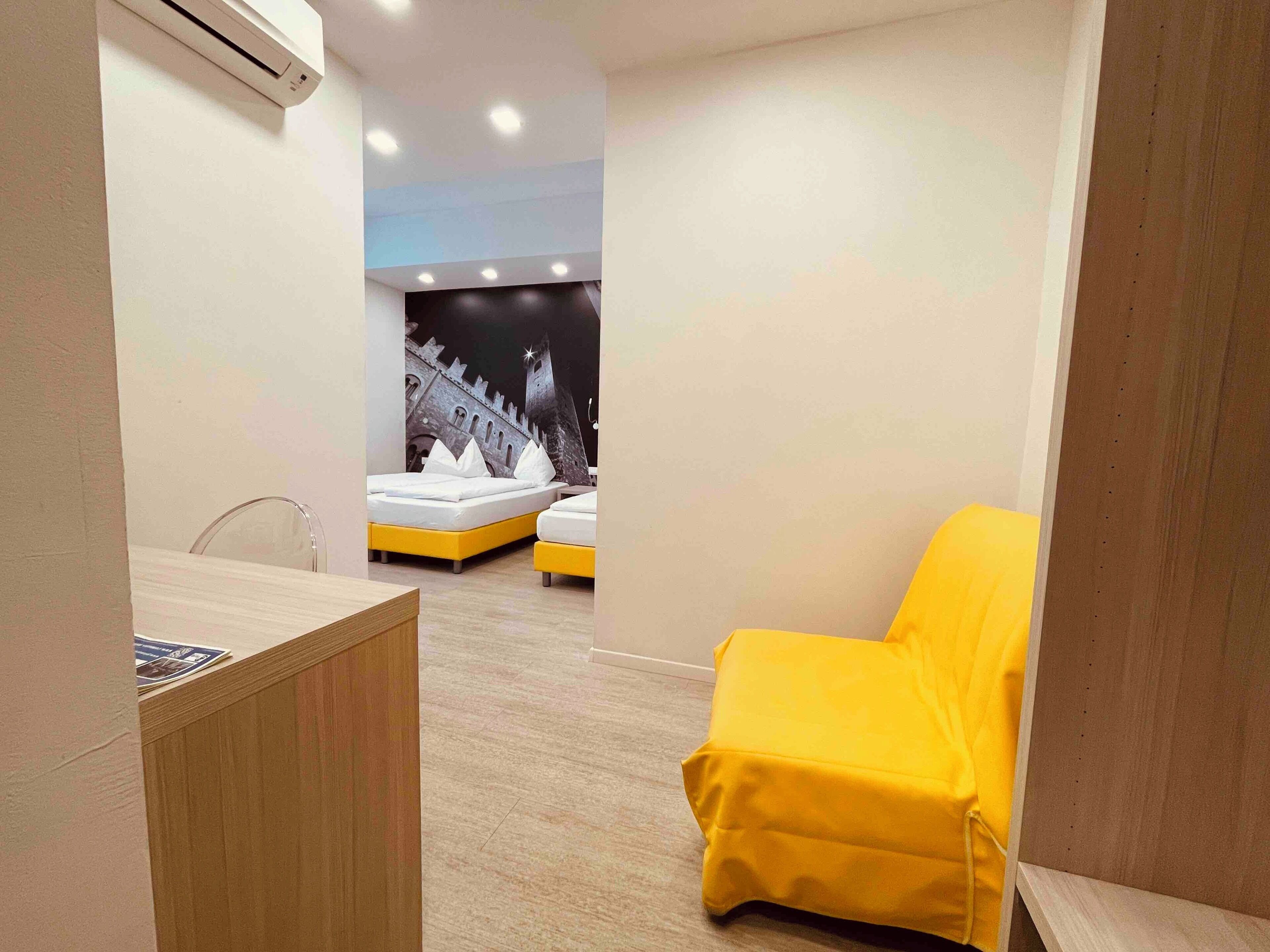 Un dormitorio moderno con una cama, un escritorio y una silla amarilla.