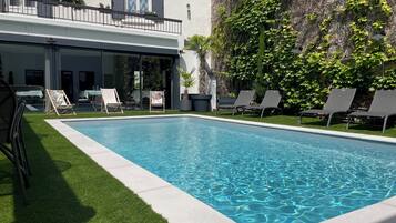 Een seizoensgebonden buitenzwembad, parasols voor strand/zwembad