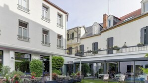 Una piscina moderna al aire libre con cerramiento de vidrio, rodeada por un césped cuidado y zonas de estar.