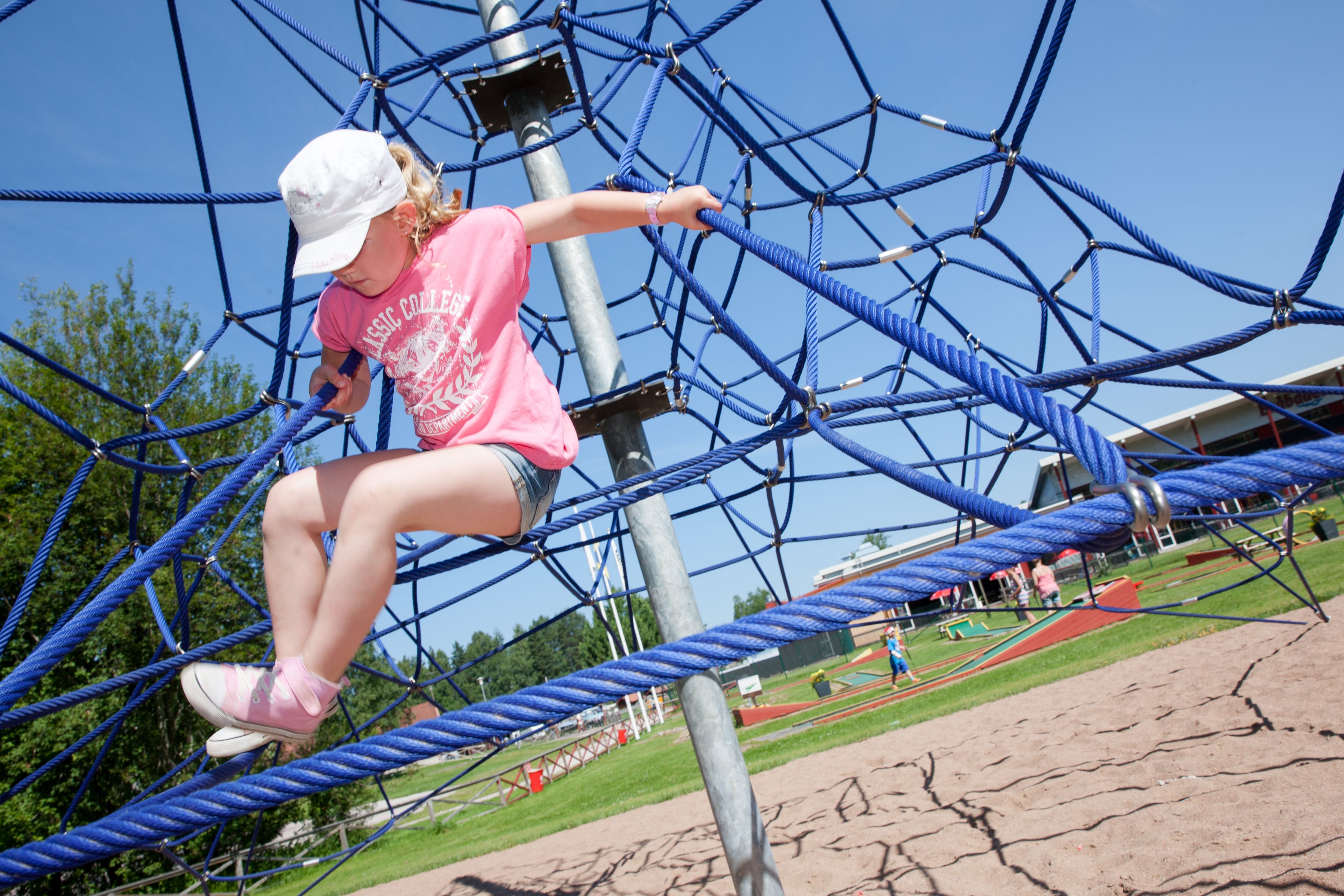 A person navigating a rope climbing structure.