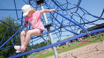 A person navigating a rope climbing structure.