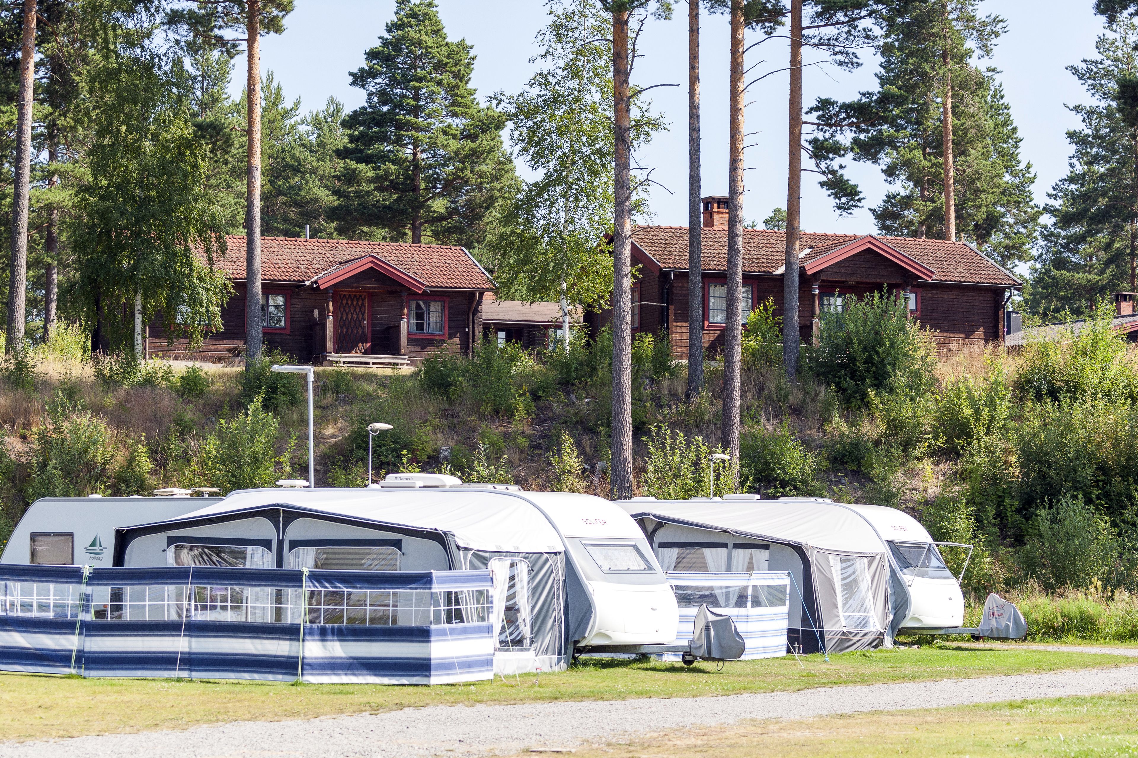 Un camping con vehículos recreativos y cabañas.