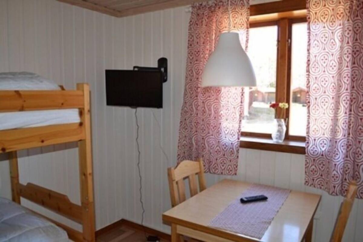 A bunk bed room with a table and a lamp.
