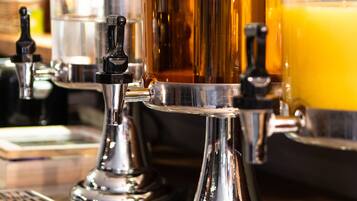 A bar with multiple taps dispensing beer and a glass of orange juice.