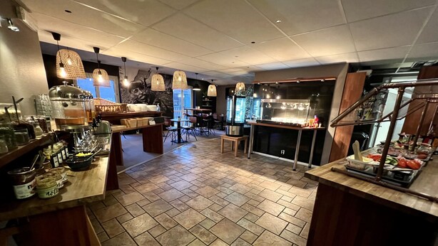 A spacious hotel lobby with a buffet area, a seating area, and a kitchen counter. - Siesta Hotell & SPA (Karlskrona)