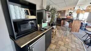 A compact kitchen with a microwave, coffee machine, and a small refrigerator. - Hotell Siesta (Karlskrona)