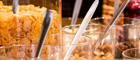 A variety of food items in clear containers with spoons, including nuts, seeds, and grains.