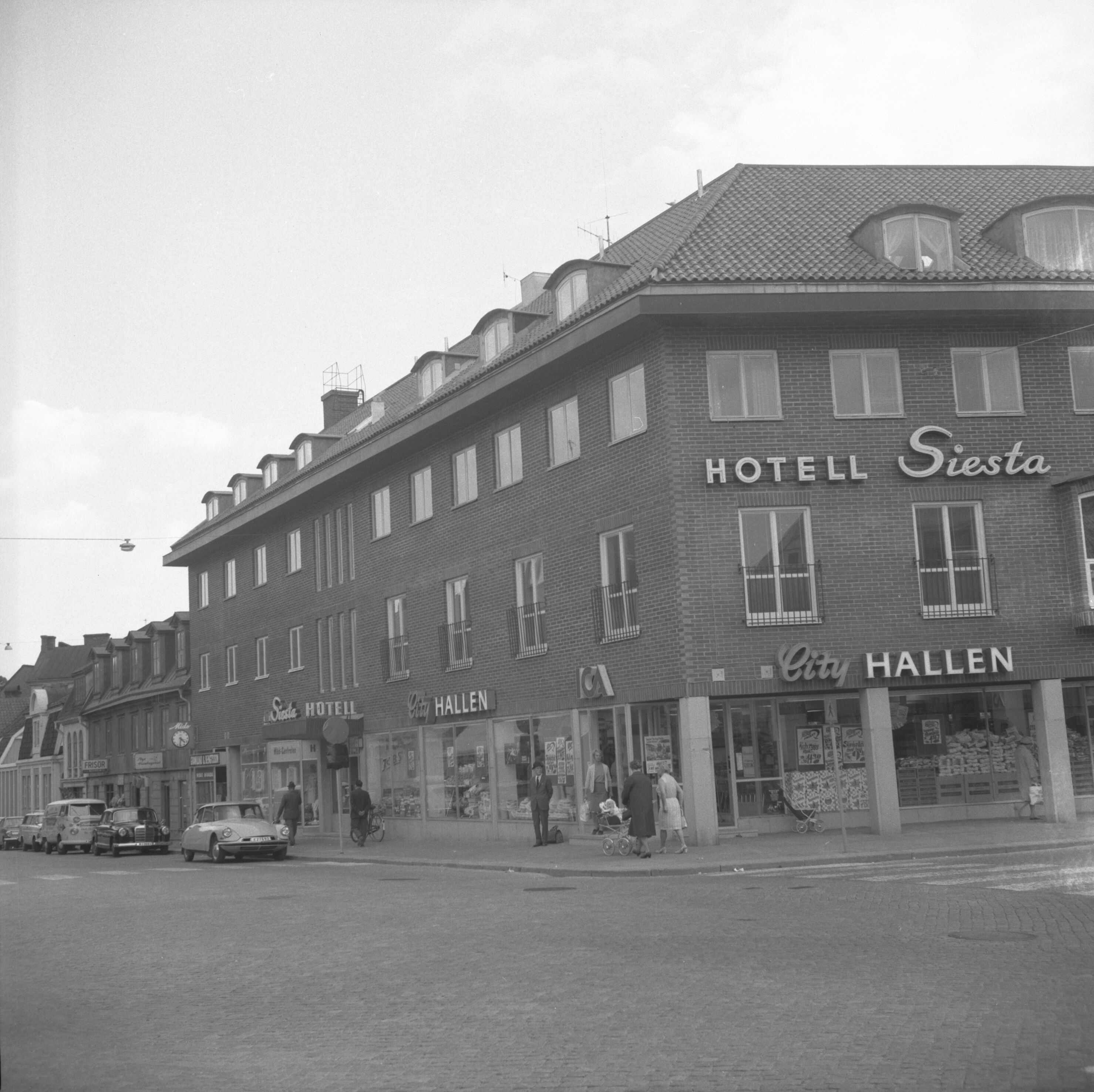 A historic hotel with a classic facade, featuring a prominent sign for HOTEL Siesta and CITY HALLEN.