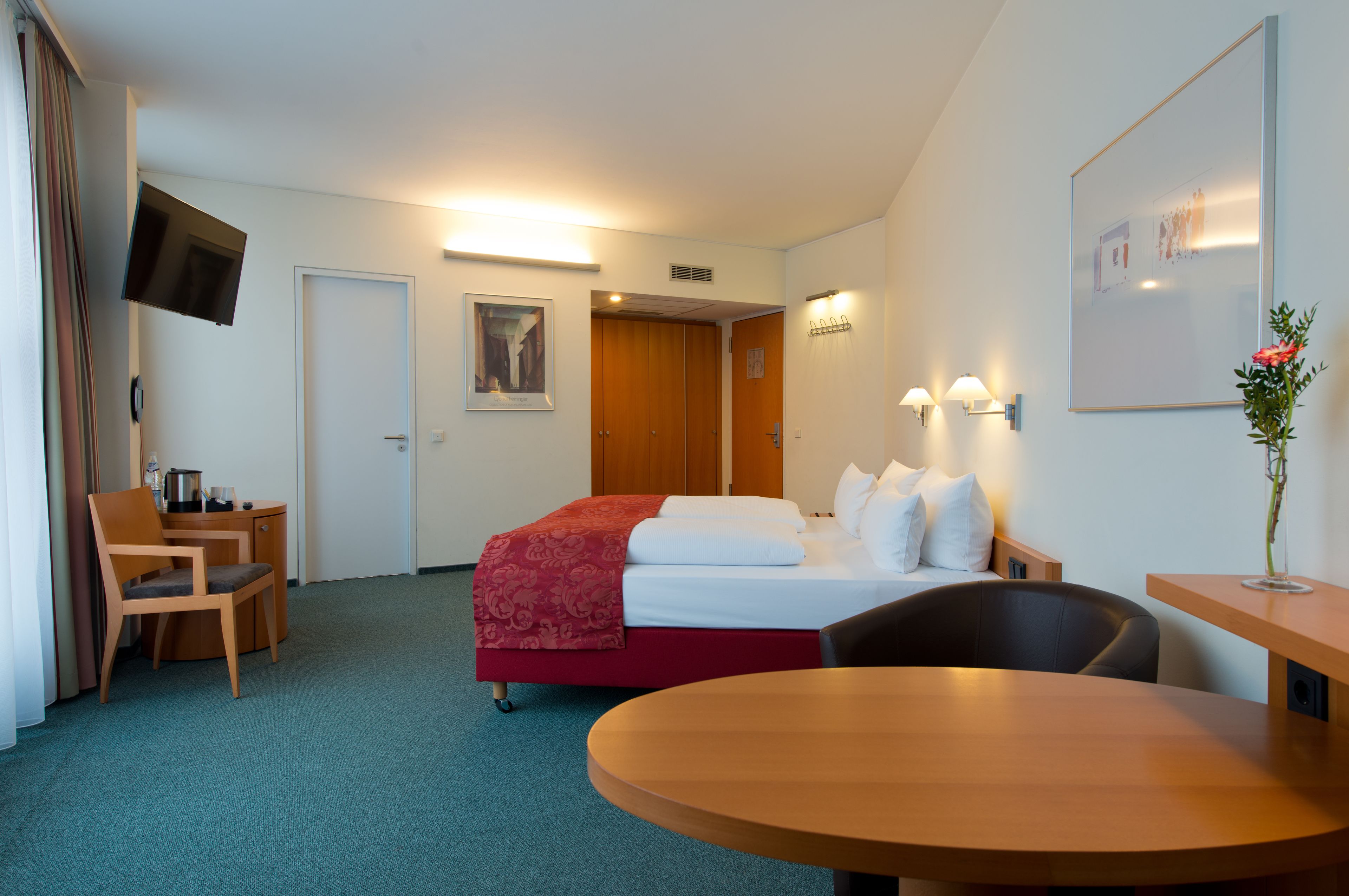 Une chambre d’hôtel avec un lit, un bureau, une chaise et une table.