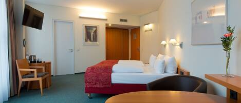 Een hotelkamer met een bed, bureau, stoel en een tafel.