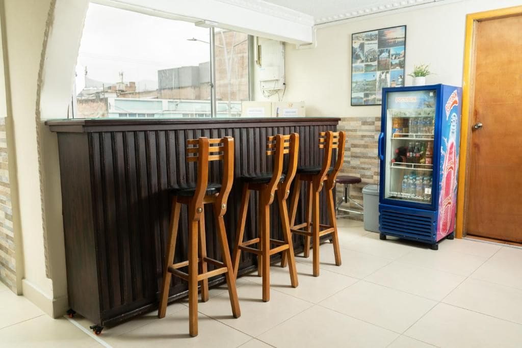 A bar area with a counter and three wooden stools.
