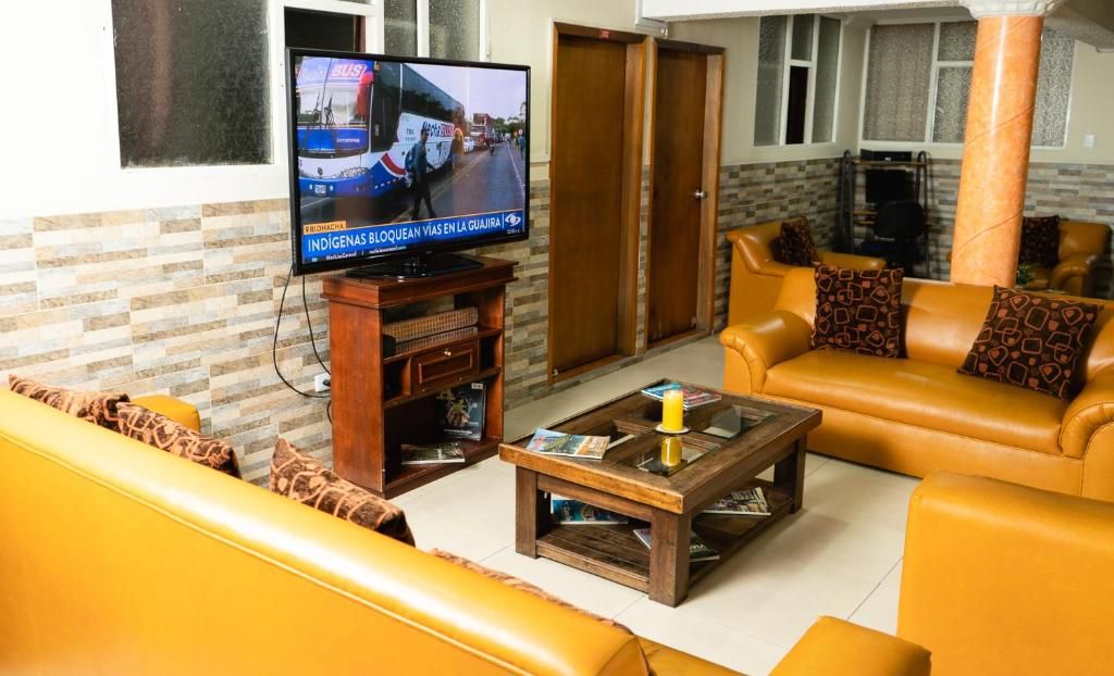 A living room with a television, a sofa, a coffee table, and a fireplace.