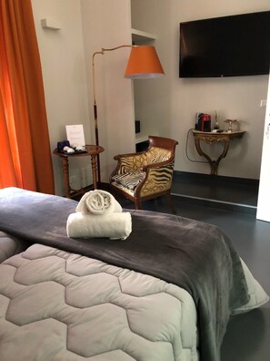 A hotel room with a bed, a chair, a table, a lamp, and a TV. - Room 94 Spagna (Rome)