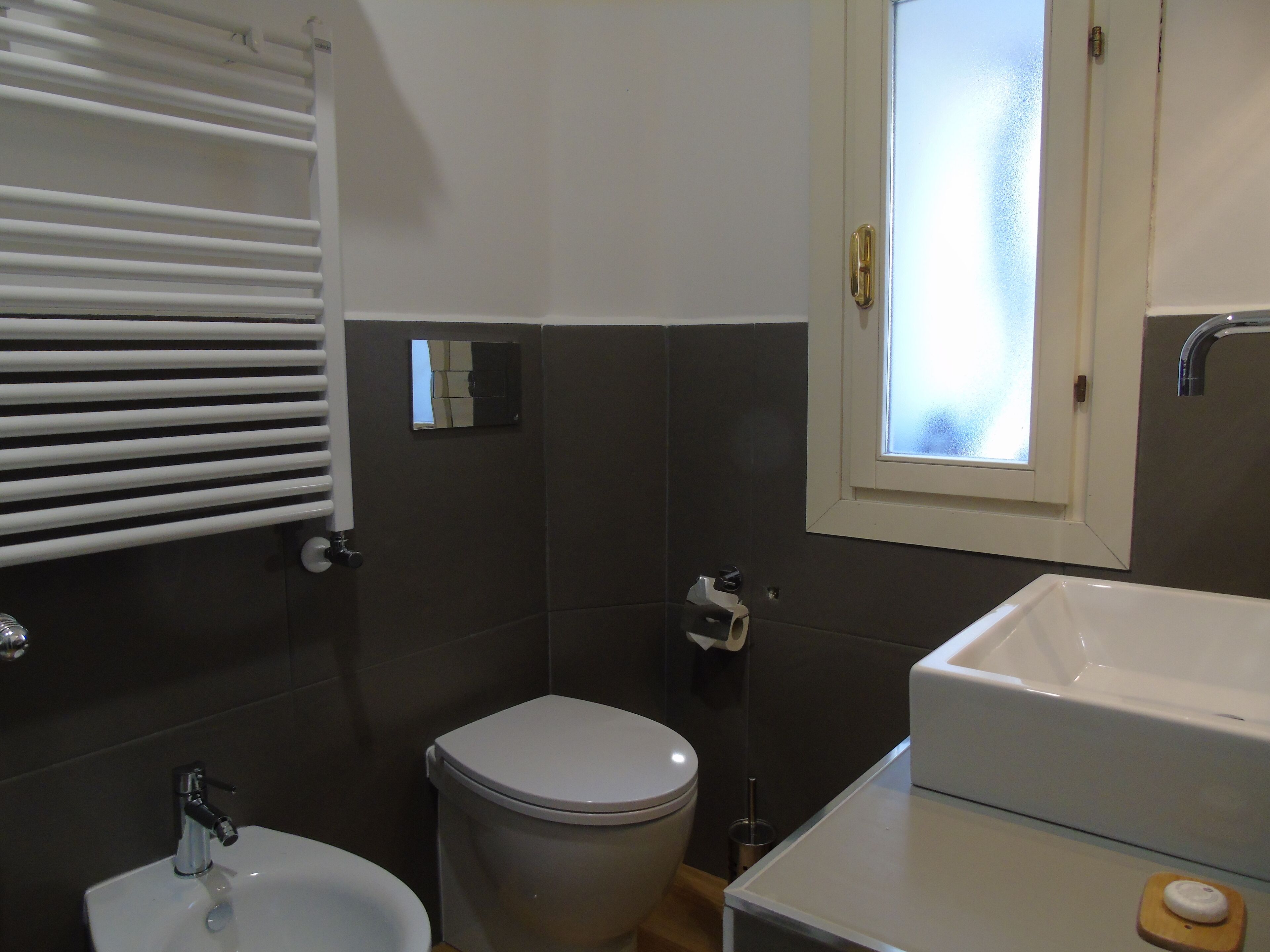 A bathroom with a toilet, bidet, and sink.