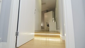 A hallway with a white door, a desk with a chair, and a cabinet. - Room Inn Vatican (Rome)