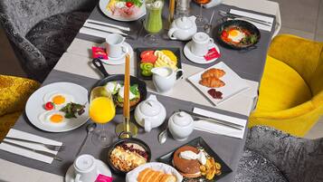 A breakfast table with various dishes, including eggs, toast, and fruit.