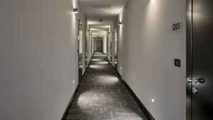 A long, narrow hallway with a dark floor, white walls, and doors on both sides. - Sia Split Hotel (Split)