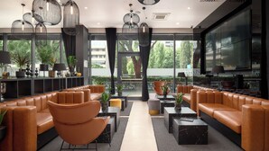 A modern lounge area with leather sofas, black and marble coffee tables, and pendant lighting. - Sia Split Hotel (Split)