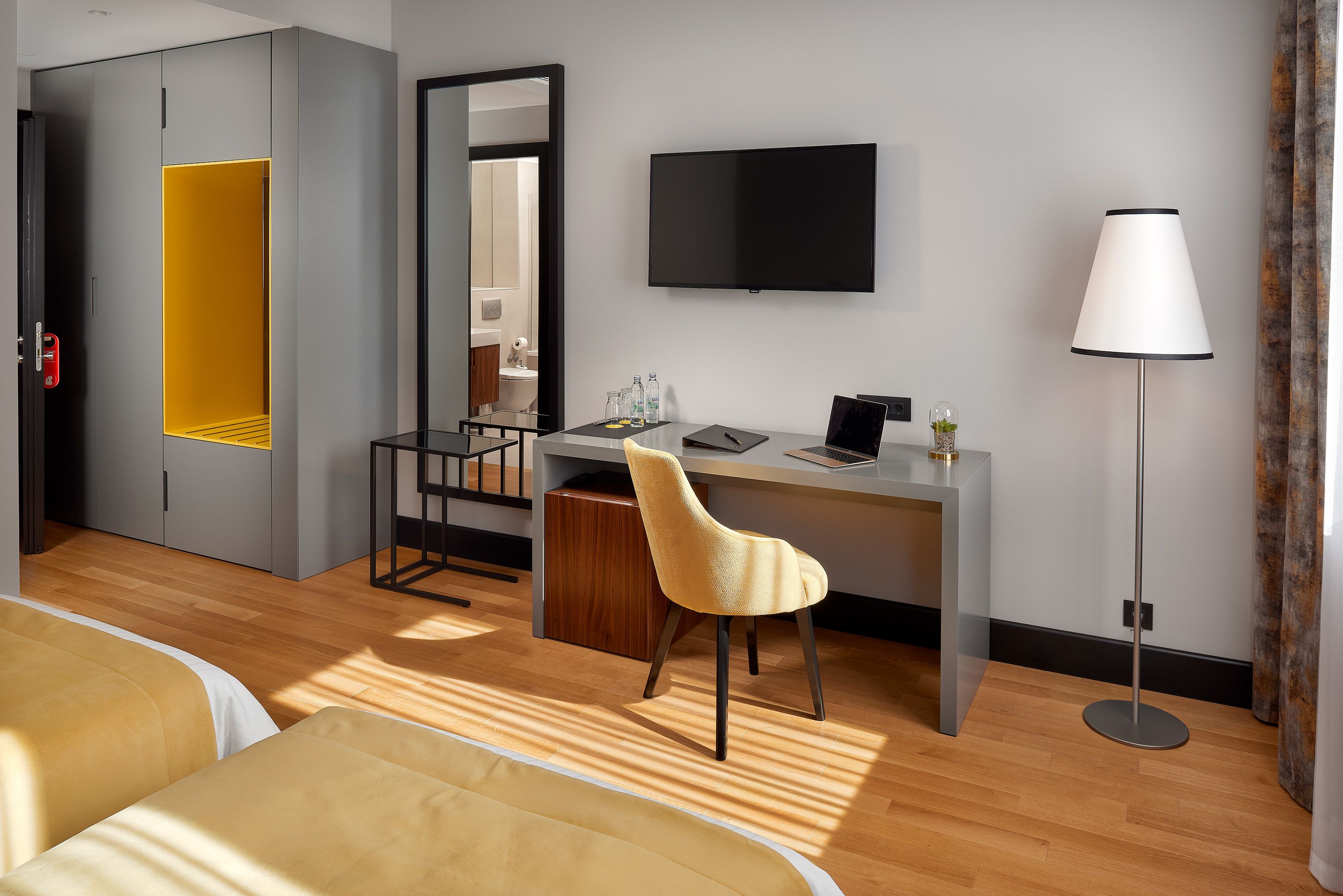 Une chambre d’hôtel comprenant un lit, un bureau avec une chaise, une télévision et une lampe.