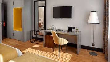 Une chambre d’hôtel comprenant un lit, un bureau avec une chaise, une télévision et une lampe.