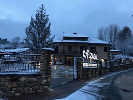 Un hotel con entrada de piedra, un letrero que dice "Calzada Hotel Restaurant" y un paisaje cubierto de nieve.