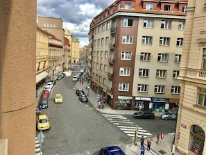 A street view with buildings, cars, and pedestrians.