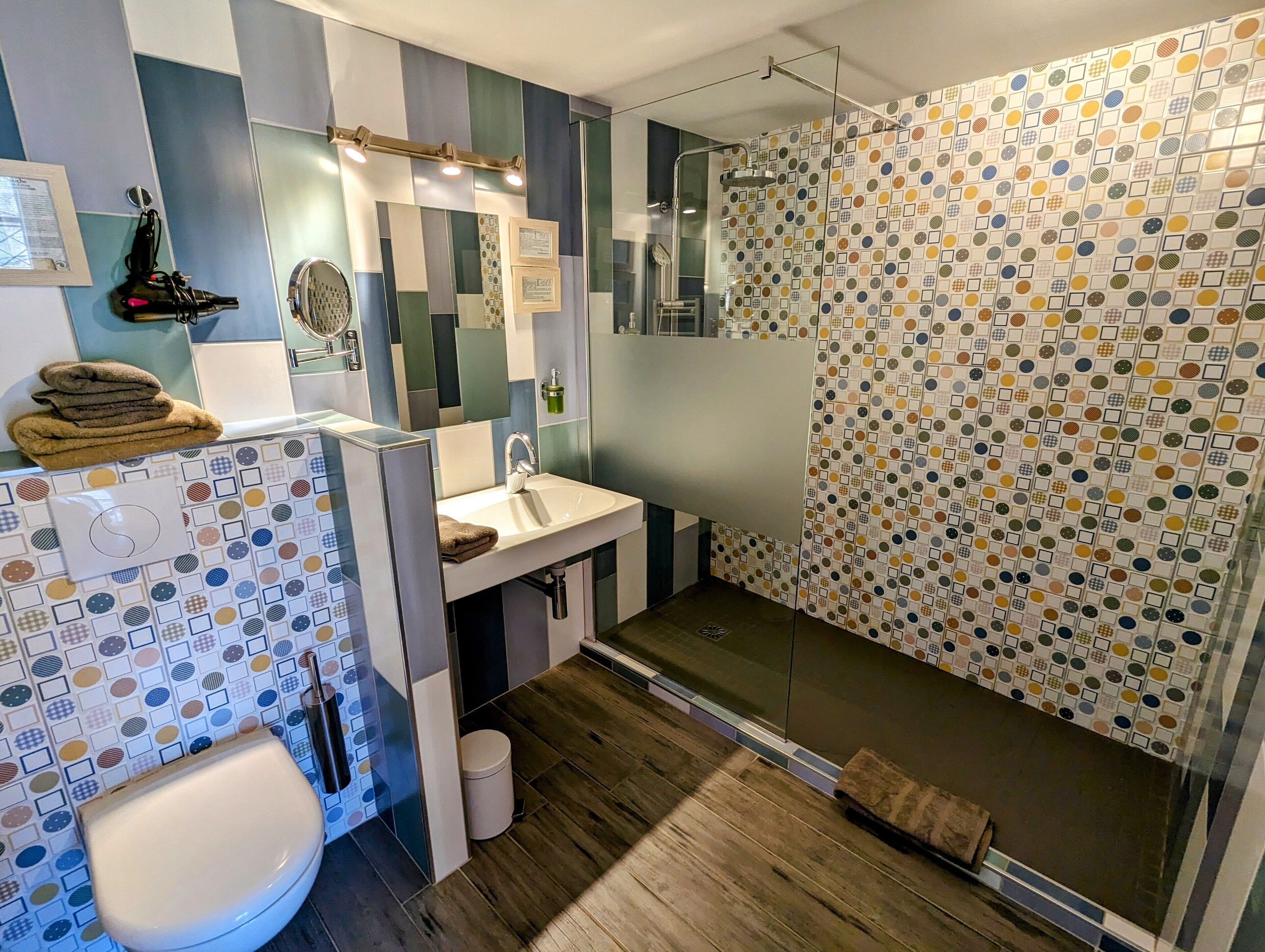 A modern bathroom with a shower, toilet, and sink.
