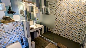 A modern bathroom with a shower, toilet, and sink.