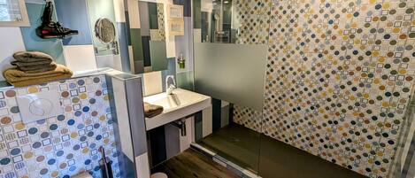 A modern bathroom with a shower, toilet, and sink.