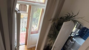 A room with a wooden herringbone floor, a sliding glass door leading to an outdoor area, and a potted plant. - Apartment Siroka 14 (Prague)