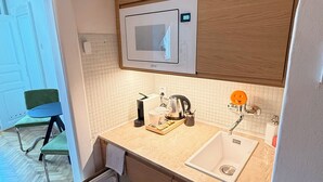 A compact kitchen with a microwave, sink, and a small refrigerator. - Apartment Siroka 14 (Prague)