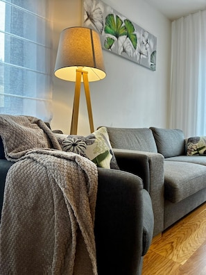 A living room with a sofa, a floor lamp, and a painting on the wall. - Residence Grand Suites (Spindleruv Mlyn)