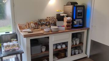 Un bar pour le petit-déjeuner équipé d’une machine à café, de pots de confiture et d’une variété d’aliments pour le petit-déjeuner.