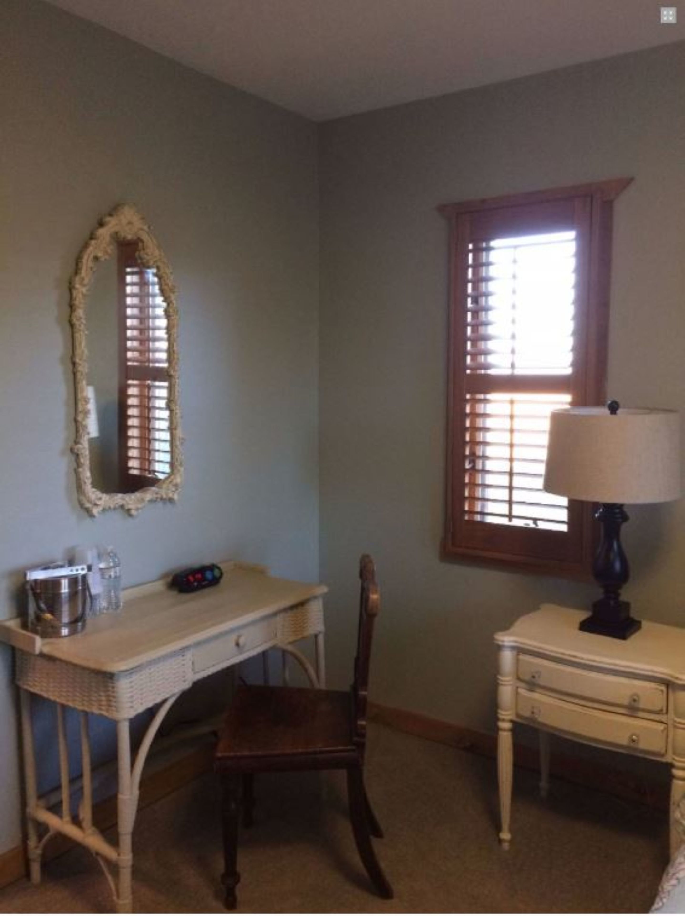 A room with a desk, chair, and a lamp.