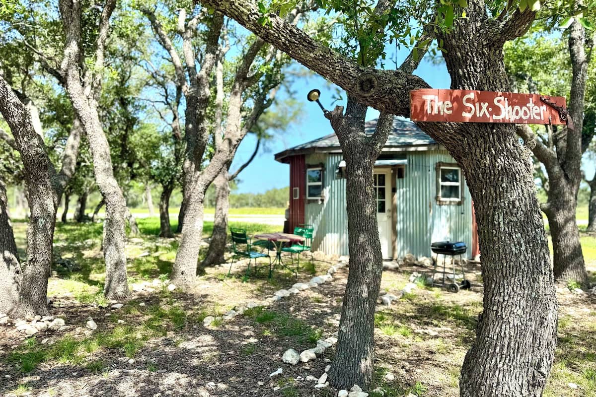 A rustic cabin with a sign reading "The Six Shooter."