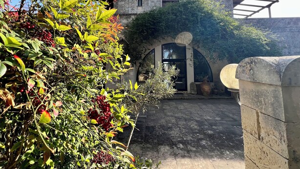 A stone building with arched doorways and a covered entrance. - Albergo Masseria Gattamora (Uggiano la Chiesa)