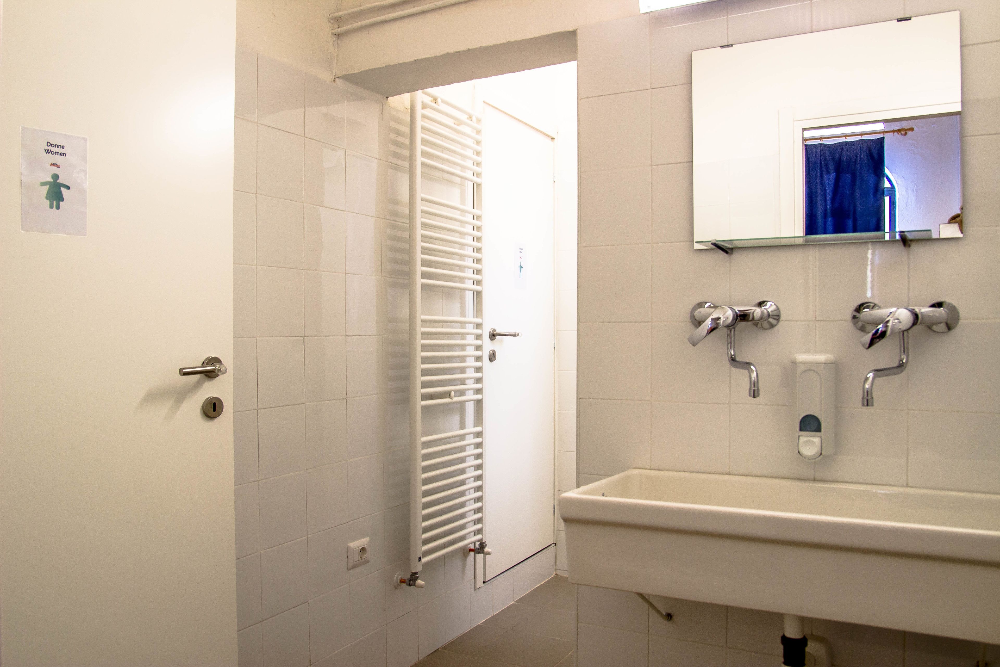 A bathroom with a white sink, mirror, and towel rack.