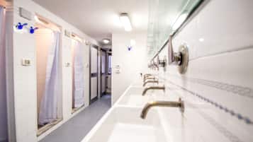 A hotel bathroom with multiple sinks and showers.