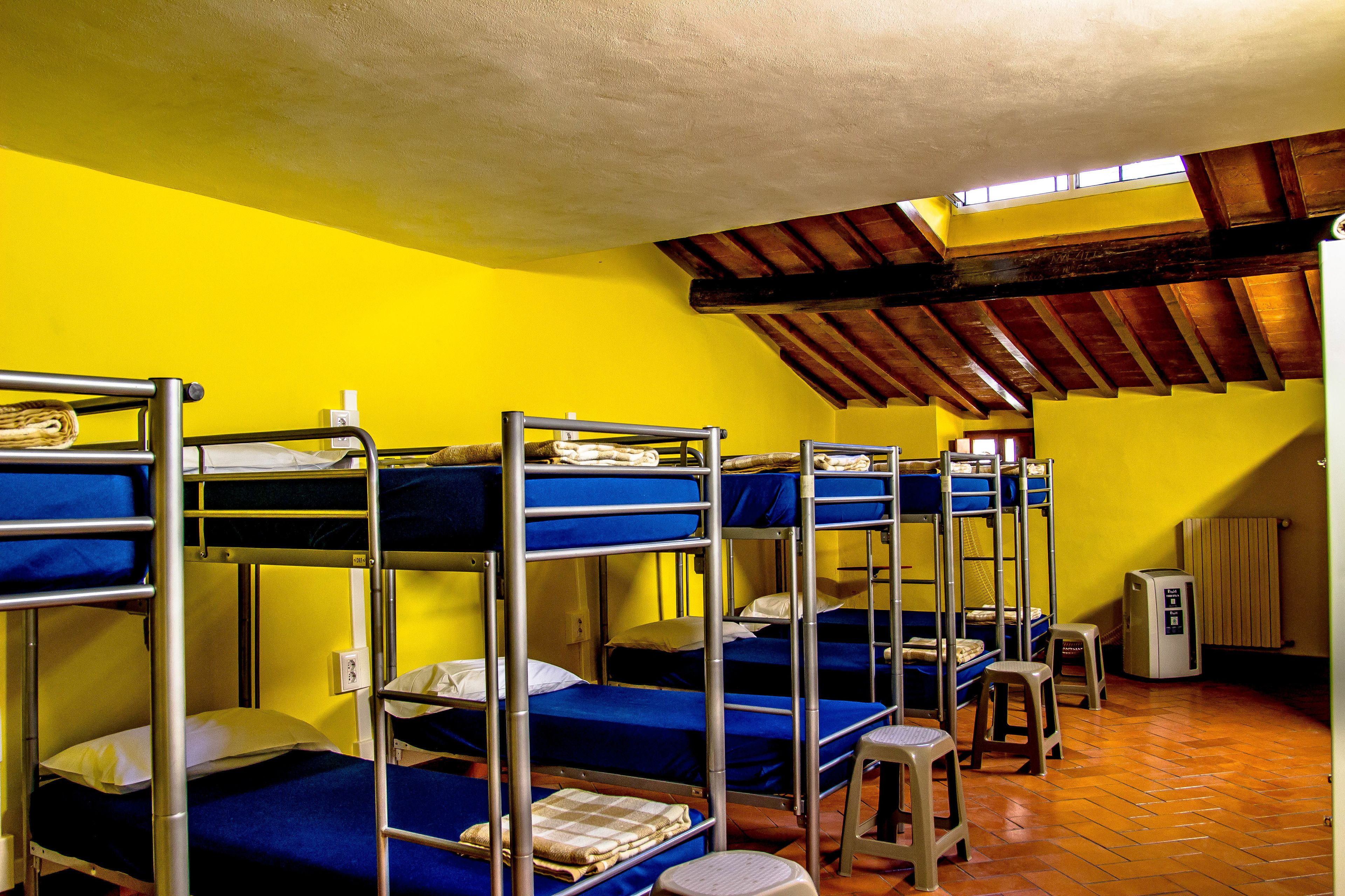 Una camera del dormitorio con letti a castello, termosifone e finestra.