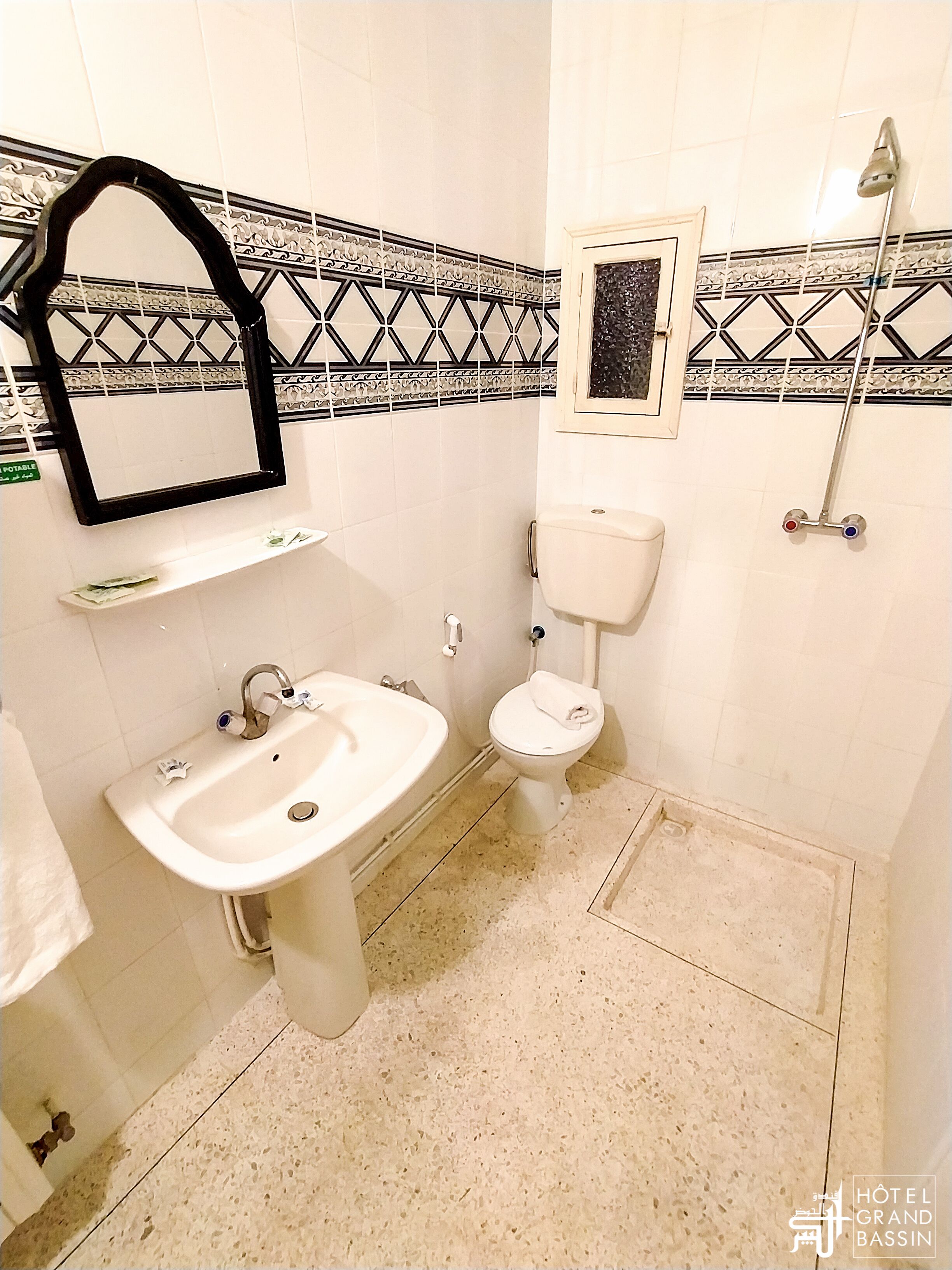 A bathroom with a sink, toilet, and shower.