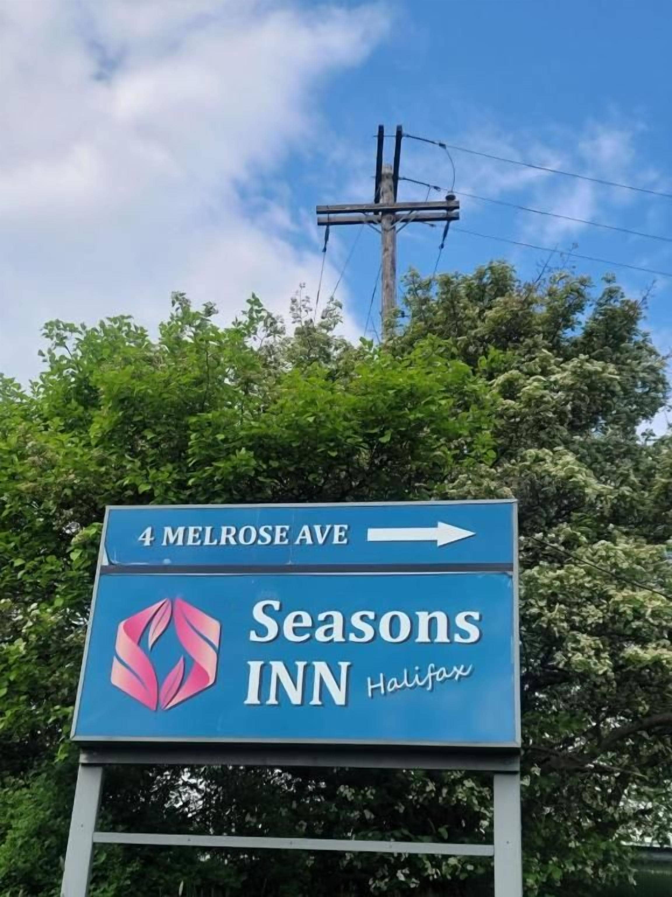 A Seasons Inn sign with a directional arrow pointing right, indicating the direction to 4 Melrose Ave.