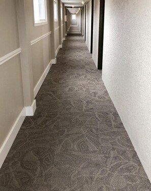 A long, narrow hallway with patterned carpet and white trim. - Seasons Inn Halifax (Halifax)
