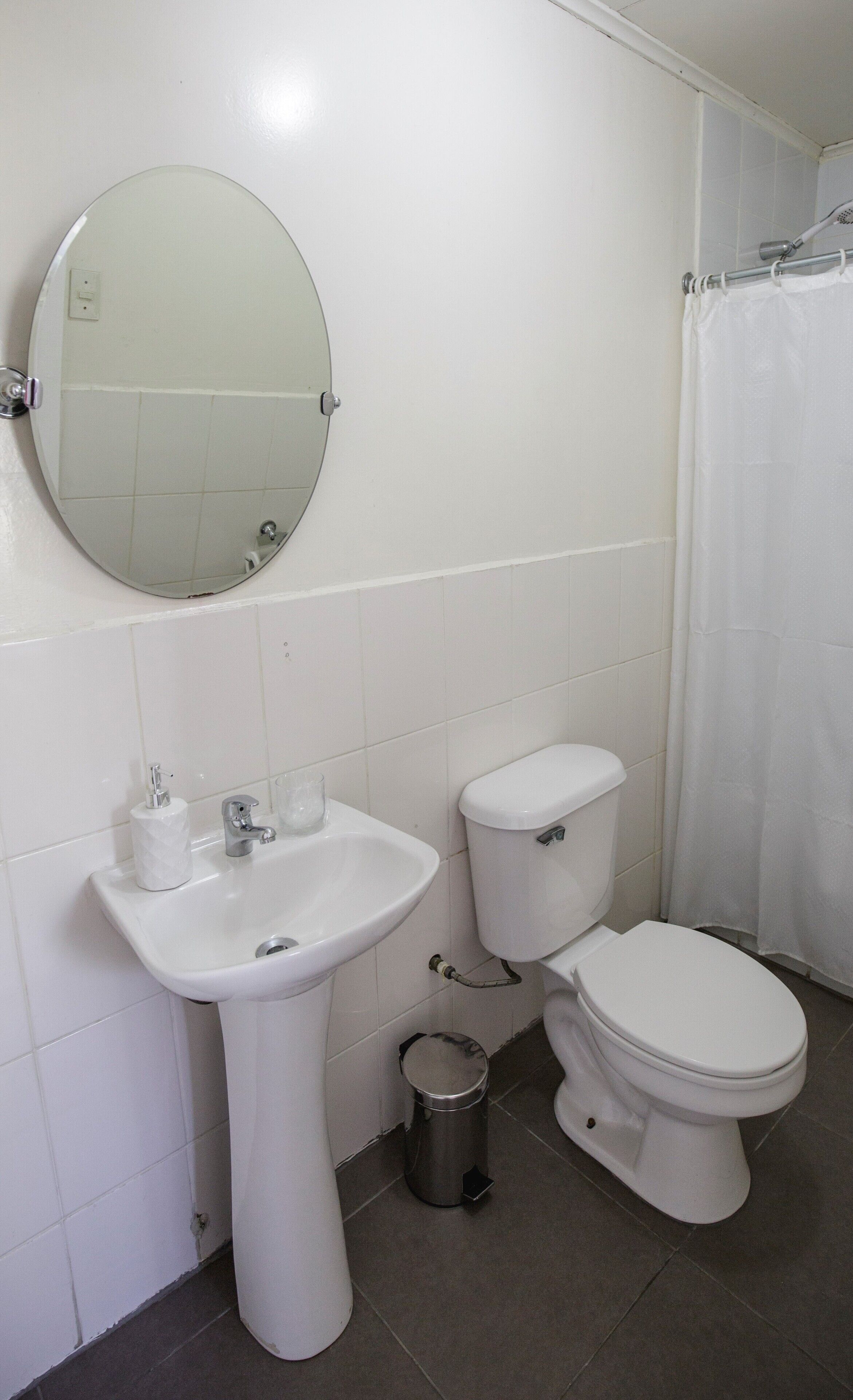 A bathroom with a sink, toilet, and a shower curtain.