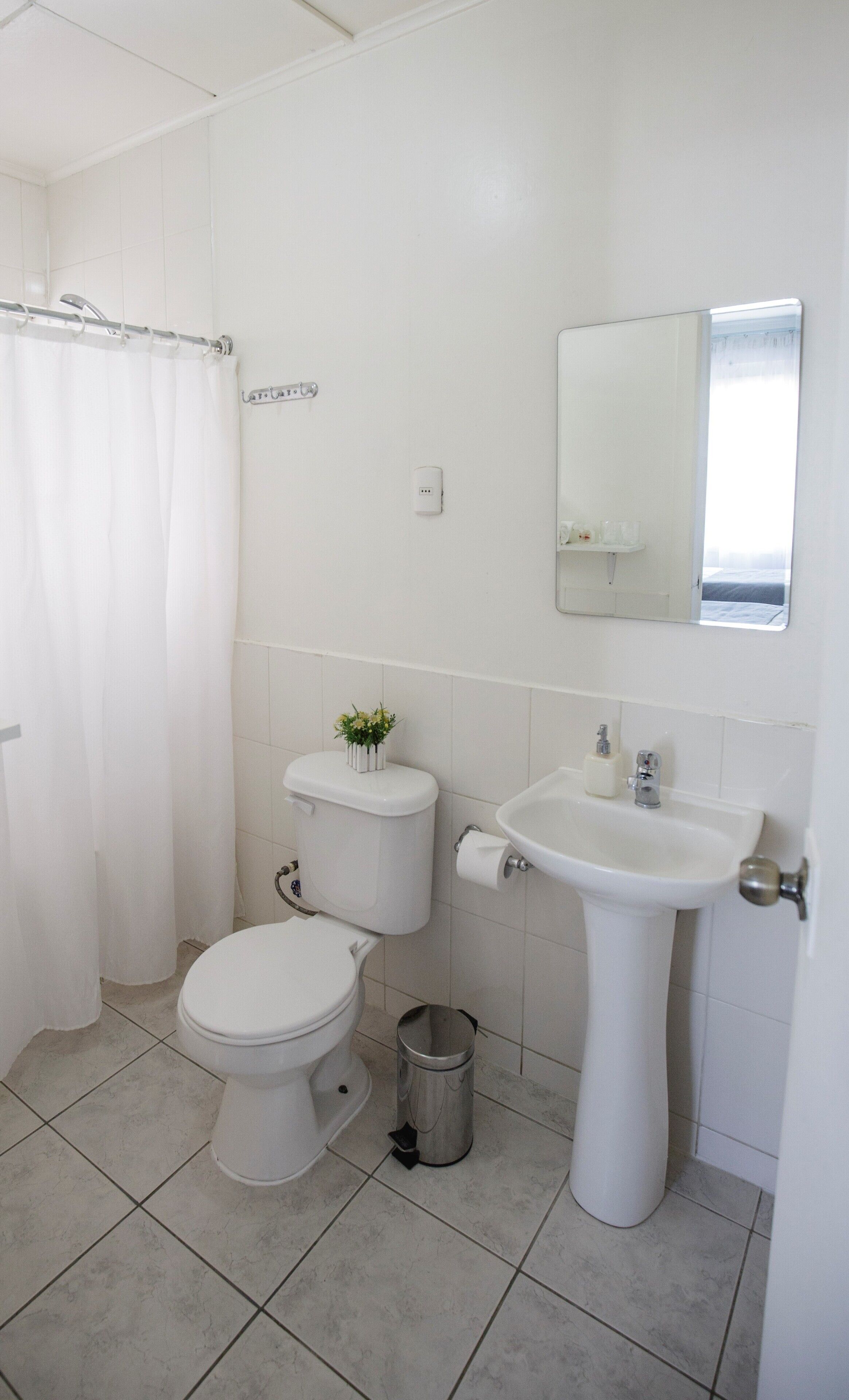 Un baño pequeño y limpio con inodoro, bidé y lavamanos.