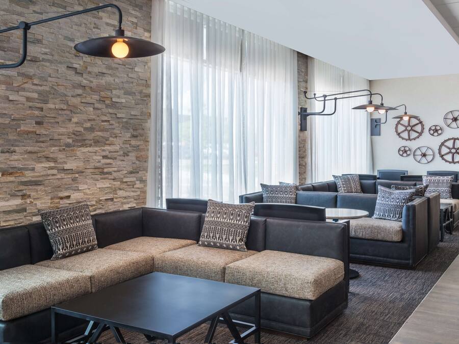 A modern lounge area with leather sofas, a coffee table, and wall-mounted lighting.