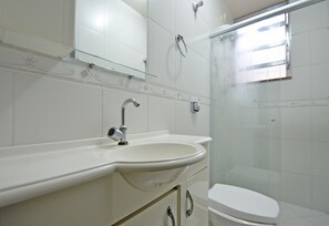 A bathroom with a white sink, mirror, and toilet. - LineRio Copacabana Family Residence 322 (Rio de Janeiro)