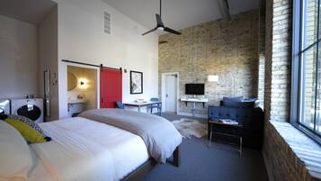 Une chambre d’hôtel moderne équipée d’un grand lit, d’un bureau, d’un canapé et d’une télévision.