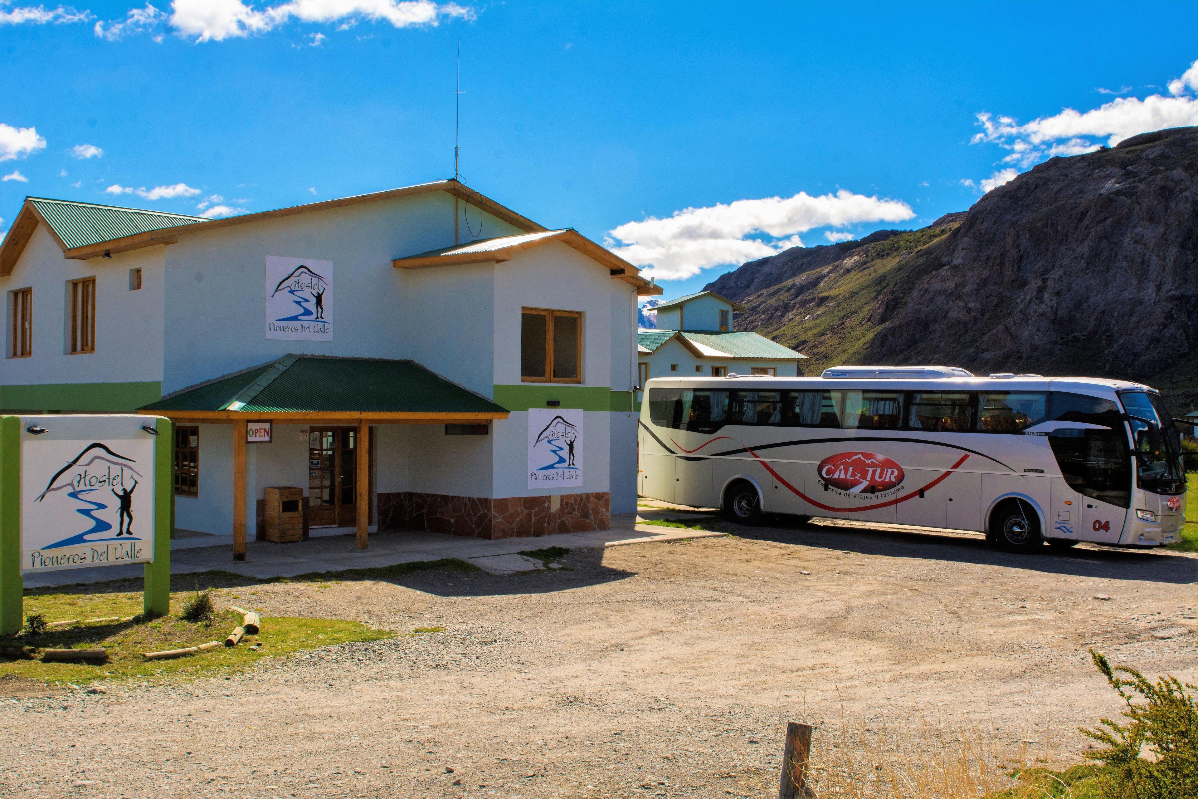 Ein Hostel mit Gründach und einem Bus vor der Tür.