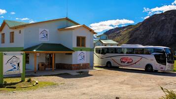 Ein Hostel mit Gründach und einem Bus vor der Tür.