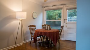 Un espace repas comprenant une table, des chaises, un lampadaire et un ventilateur de plafond.